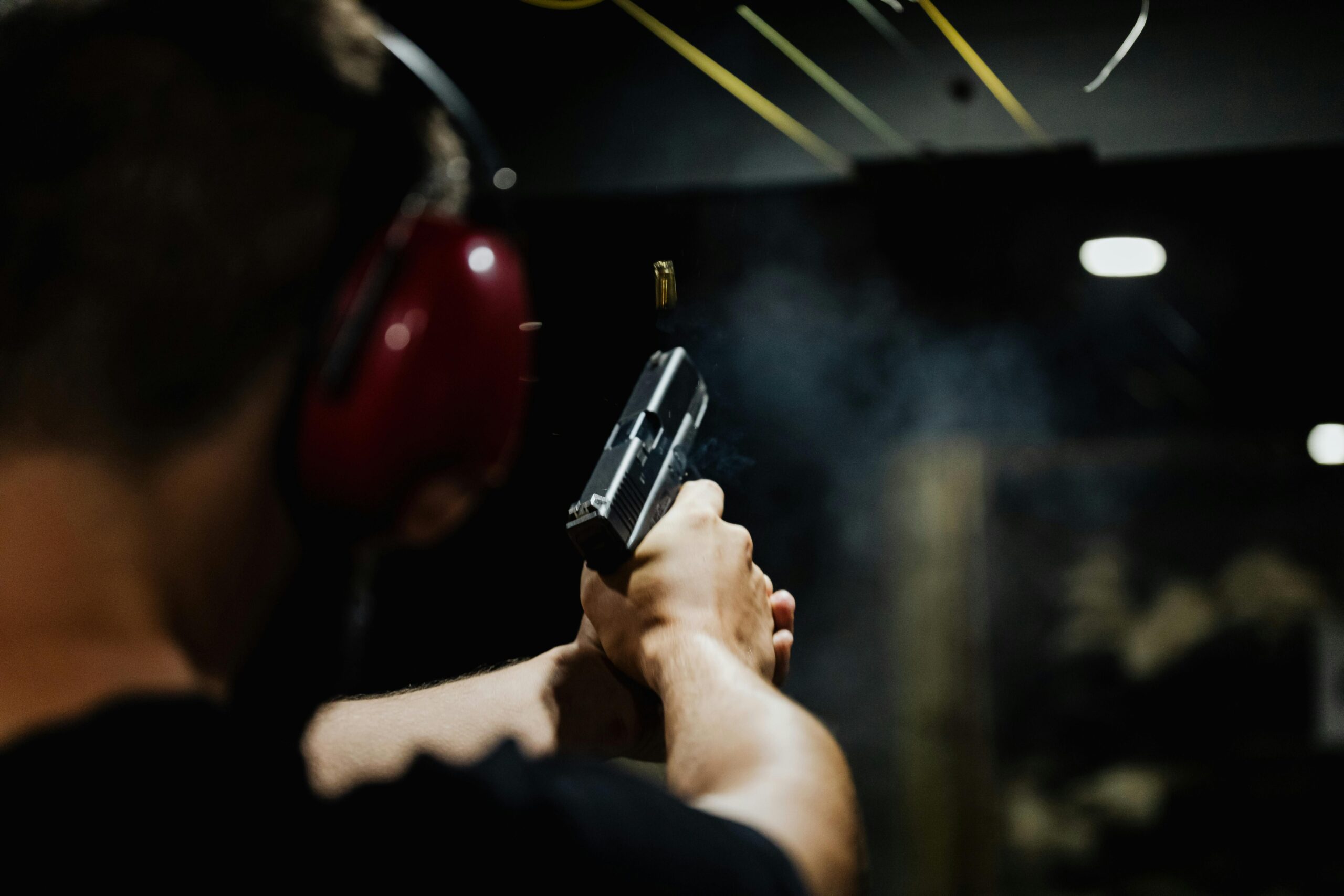 man shooting gun at indoor range